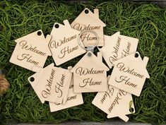 wooden tags with names on them sitting in the grass next to a pair of scissors