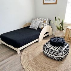 a room with a bed, chair and rug in it