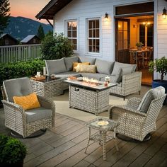 an outdoor living area with wicker furniture and fire pit in the middle of it