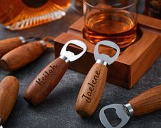 three bottle openers sitting on top of a table next to some bottles and glasses