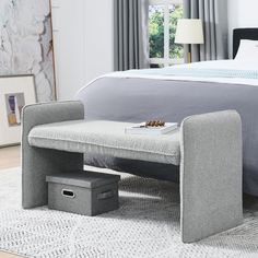 a bedroom with a bed, nightstands and a bench on the floor in front of it