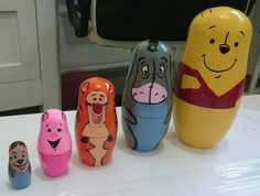 five different colored wooden toys sitting on top of a white table next to each other