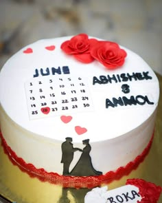 a white cake with red roses on it and a date written on the frosting