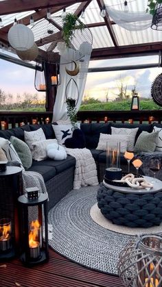 an outdoor living area with lots of furniture and lanterns on the floor, along with candles