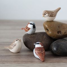 small ceramic birds sitting on top of rocks