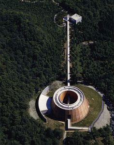 an aerial view of a circular building surrounded by trees