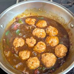 some meatballs are cooking in a pot on the stove