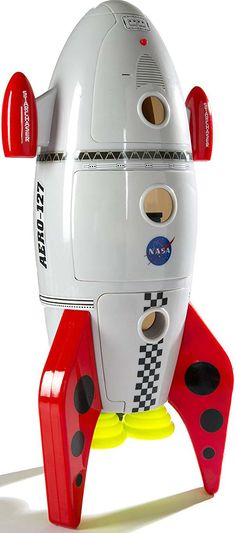 a white and red toy rocket with black dots on it's side, sitting in front of a white background