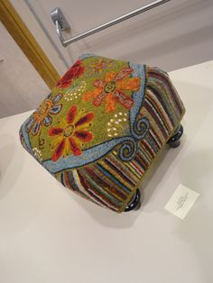 a colorful purse is on display in a museum exhibit with other items around the room