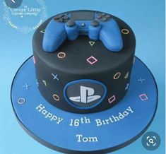 a blue and black birthday cake with two video game controllers on the top, happy 16th birthday tom