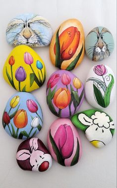 painted rocks with animals and flowers on them are arranged in the shape of an egg