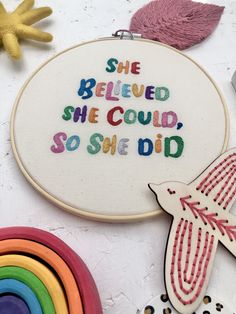 there is a cross stitch pattern on the wall next to some other crafting supplies