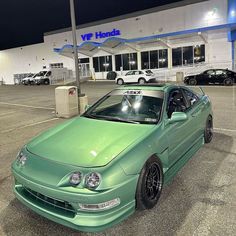 a green car parked in front of a building