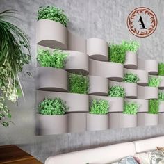 a living room filled with lots of plants on top of a white couch next to a wall mounted planter