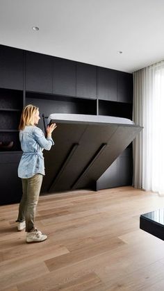 a woman standing in front of a black shelf