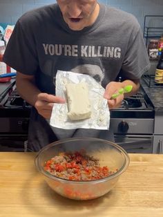 a man in a kitchen preparing food on top of a wooden table