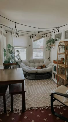 a living room filled with furniture and a book shelf on top of a hard wood floor