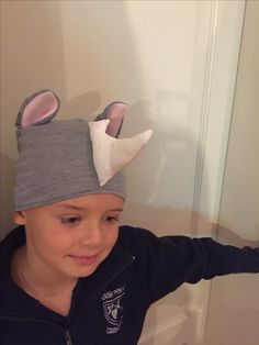 a young boy wearing a hat with ears on it