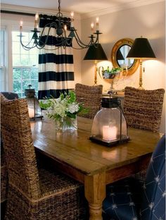 a dining room table with some chairs and a vase on the table next to it