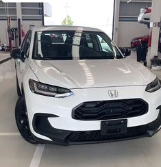 the front end of a white car in a garage