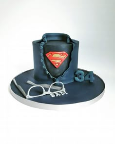 a birthday cake with a superman hat and glasses