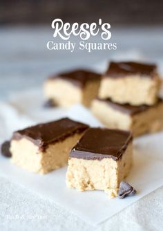 pieces of peanut butter and chocolate candy squares sitting on top of a piece of parchment paper