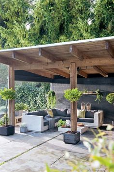 an outdoor living area with couches and potted plants