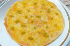 a pizza with cheese and green peppers on a plate