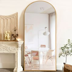 a white table and chairs in a room with a large mirror on the wall above it