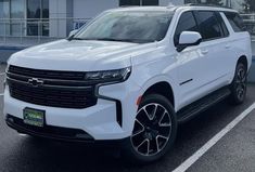 a white chevrolet suv parked in front of a building