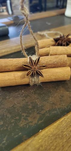 cinnamon sticks tied with twine and star anise on top of a wooden table