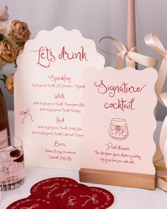 the table is set up with two wine glasses and place cards for guests to drink