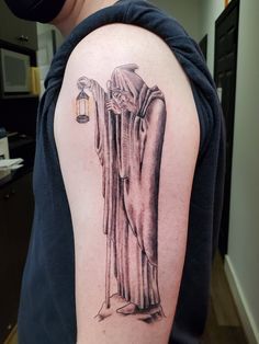 a person with a tattoo on their arm holding a light bulb and wearing a robe