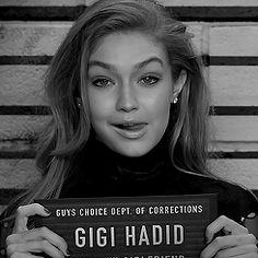 a woman holding up a sign that says gigi hadid