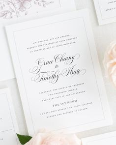 the wedding stationery is laid out on top of each other, with pink flowers