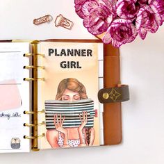 a planner book with an image of a woman's face on it and pink flowers