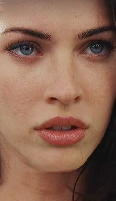 a close up of a woman with blue eyes