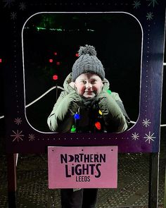 a person standing in front of a television with christmas lights on it