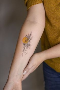 a woman's arm with a flower tattoo on the left side of her arm