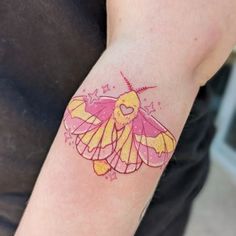 a small tattoo on the arm of a person with a pink and yellow butterfly design