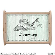 a wooden tray with an image of a mermaid holding a dolphin on it's back