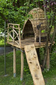 a bird house made out of branches and wood with a ladder leading up to it