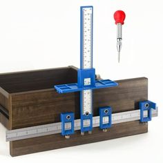 a wooden box with a measuring tape, ruler and screwdriver on top of it