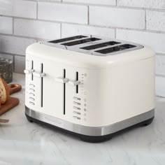 a white toaster sitting on top of a counter next to a knife and bread