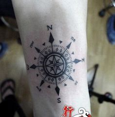 a person with a compass tattoo on their arm