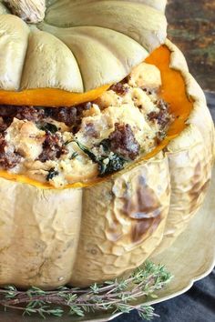 a pumpkin with stuffing in it sitting on a plate