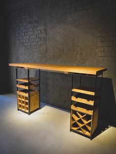 a wooden desk sitting next to a brick wall in an empty room with light shining on it