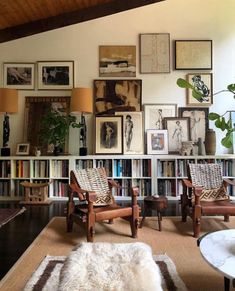 a living room filled with lots of furniture and pictures on the wall above it's bookshelf