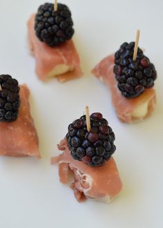 small appetizers with fruit on them sitting on a white plate