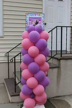 a bunch of balloons that are in front of a house with stairs and steps leading up to the door